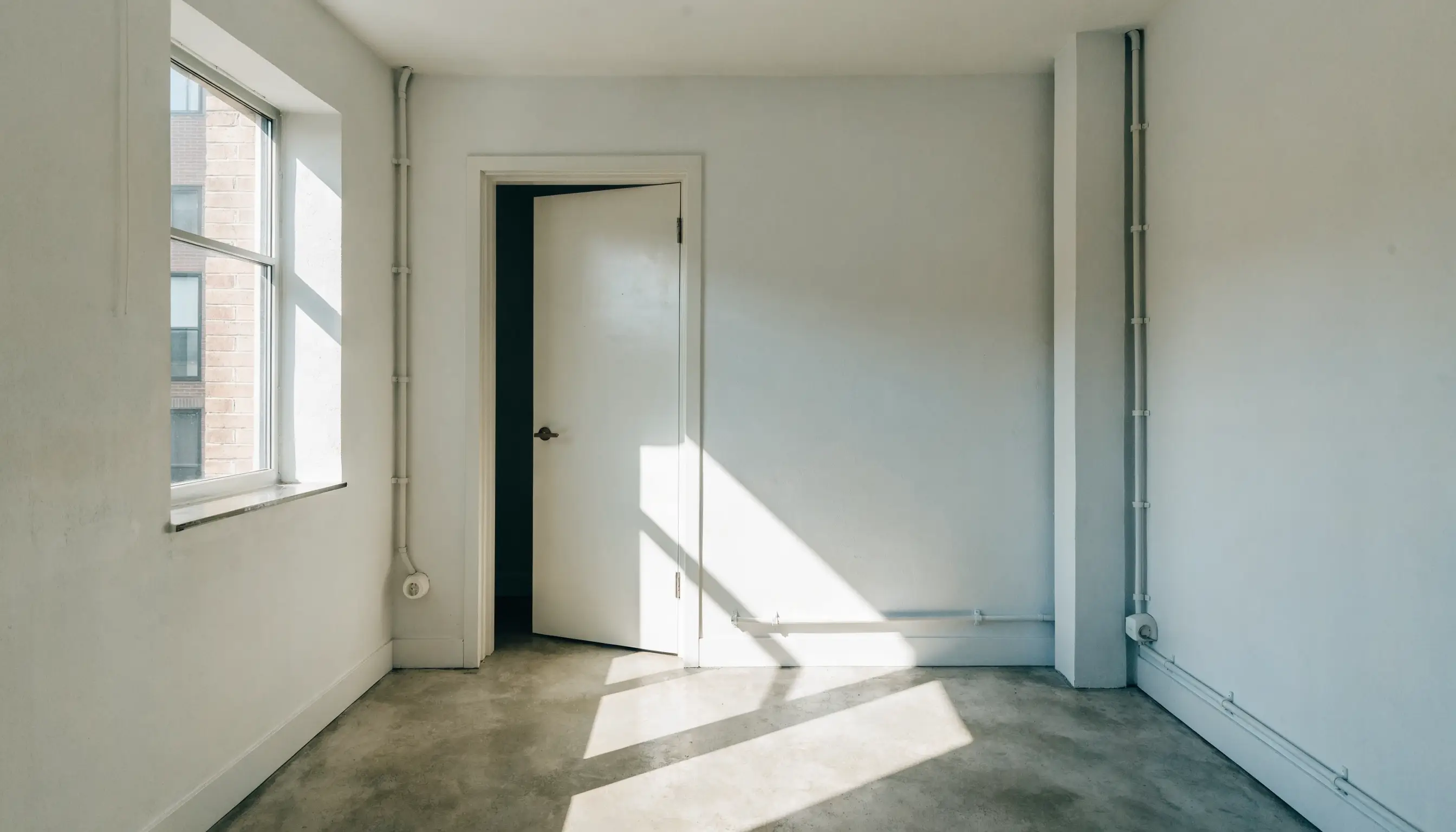 An empty room in a real estate listing, shown as captured before any virtual staging is added